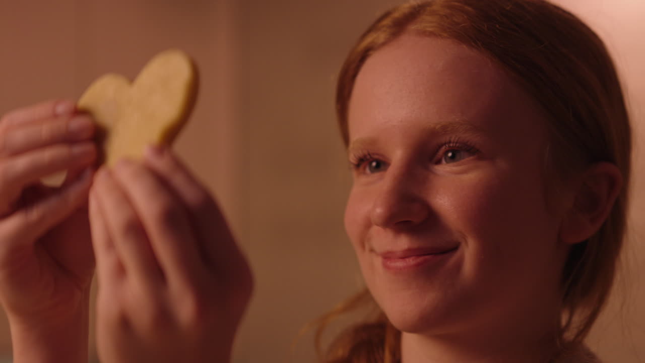Femme tenant un biscuit en forme de cœur