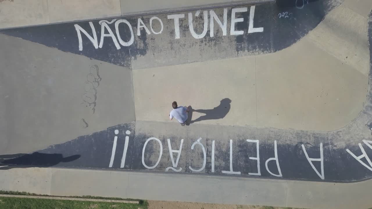 aerial view of teenager skateboarding at outdoor skate park in a estoril saying "não ao túnel" in PDG, Estoril, Cascais