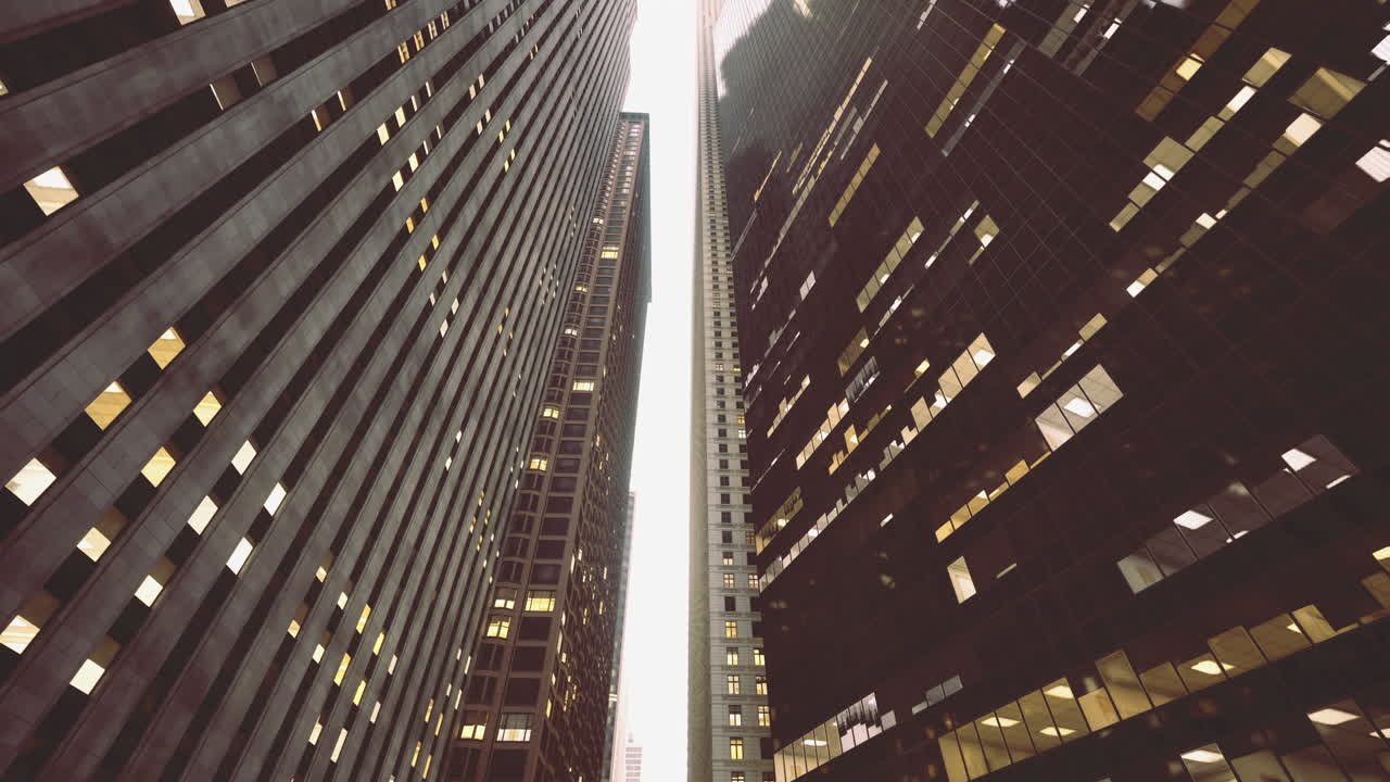 Urban canyon formed by tall buildings under cloudy sky at dusk
