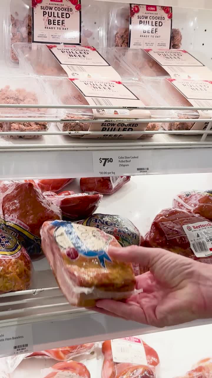 persona che sceglie carne confezionata dallo scaffale del supermercato