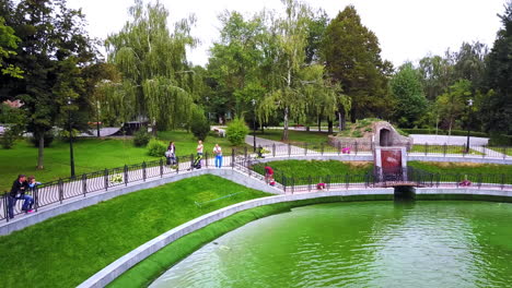 people spending time in the beautiful city park. visitors enjoying the view of fountains on the pond.