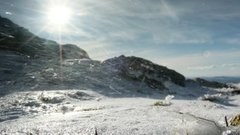 Hiker-walking-up-snowy-mountain-with-wind-blowing-snow---Ben-Resipol---Scotland