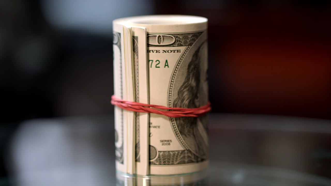 Rotating roll of hundred USA dollar bills. Cash money roll on table