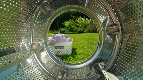 washing machine interior with laundry basket and garden view