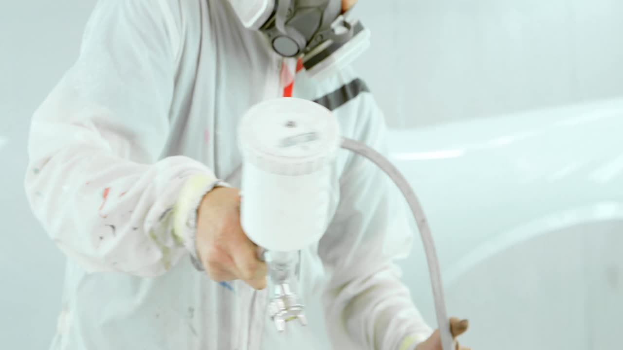 Mechanic painting car parts with electric spray gun 4k