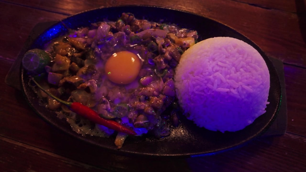 Filippiiniläinen särisevä sisig tarjoiltuna riisin ja kananmunan kera Boracayn ravintolassa.