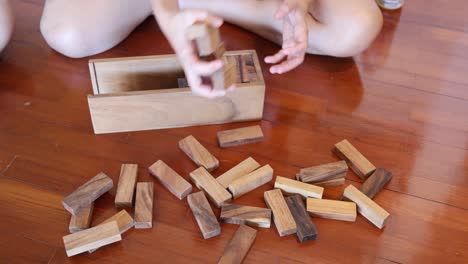 Person swiftly organizing Jenga blocks into box