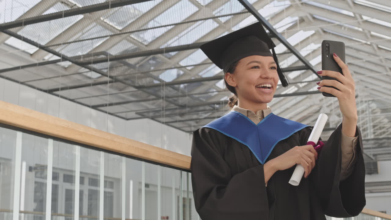 Portrait of Joyful Female Mixed-race Graduate Having Video Call