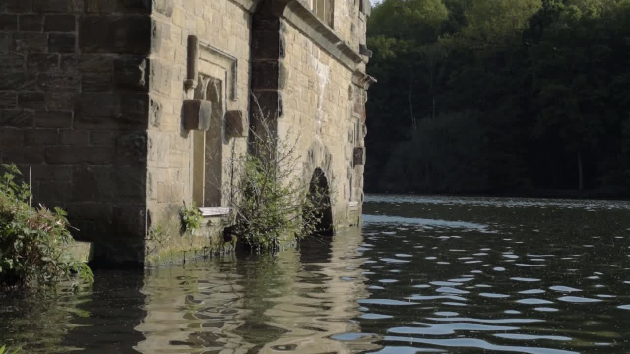 Newmillerdam Boathouse in England lake surrounded by water medium tilting shot