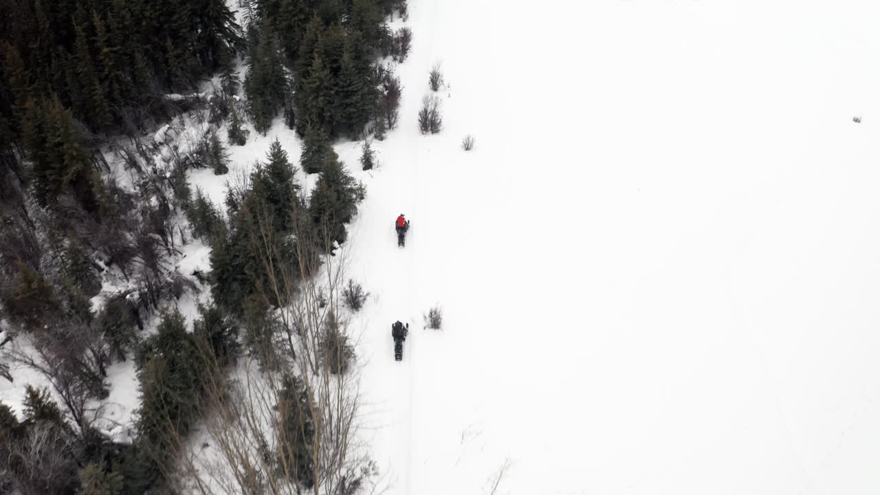 disparo de drone a vista de pájaro de dos personas en motos de nieve