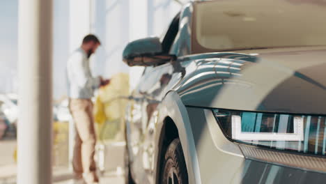 hombre examinando un nuevo coche eléctrico