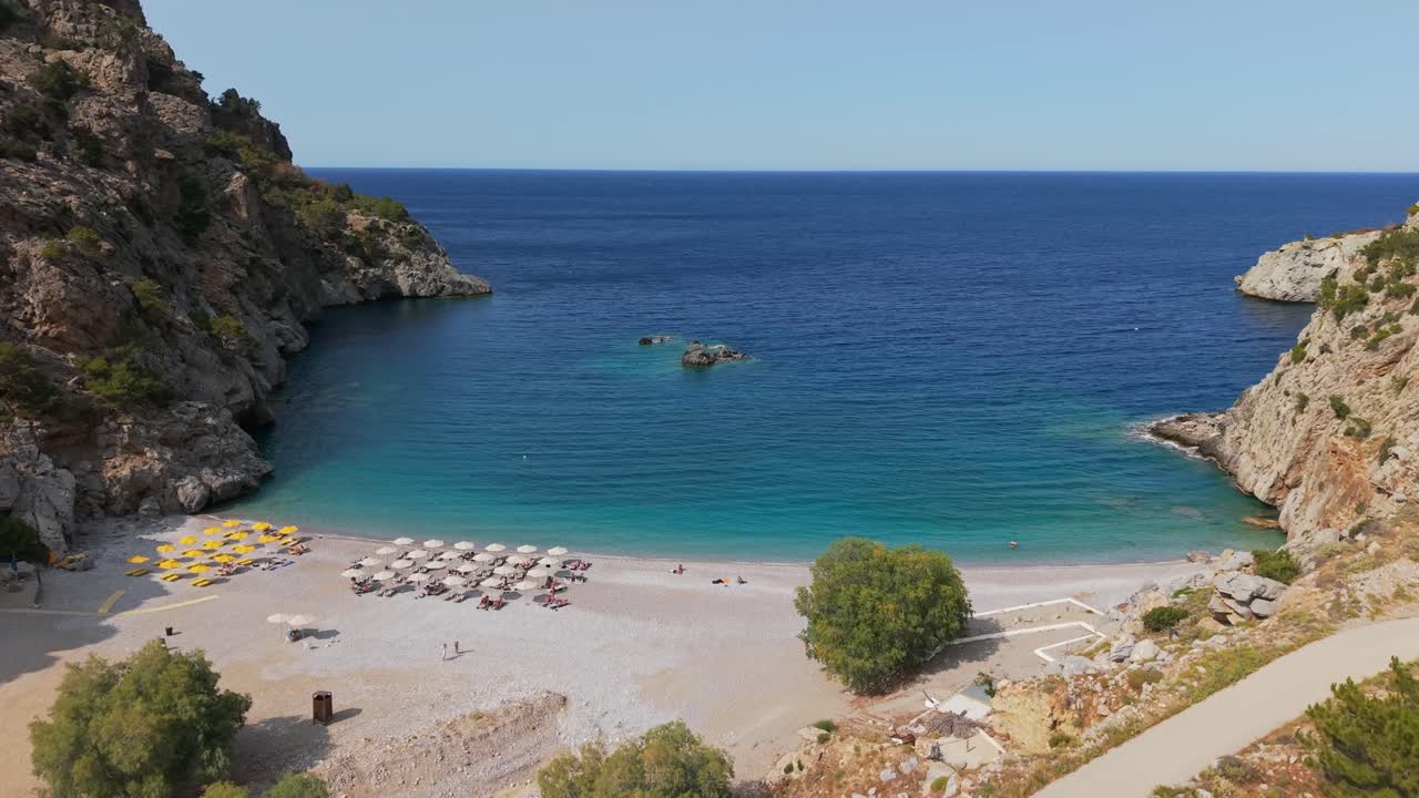 Aerial drone view of Achata sandy beach in Karpathos, Greece, surrounded by rocks and mountains