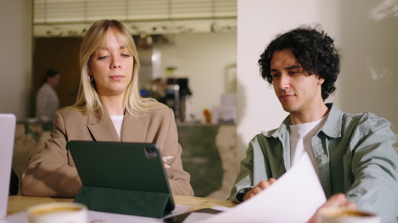 Two colleagues having a business meeting in a coffee shop