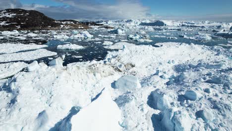 pure white color snow covered icebergs near greenland coastline, aerial view