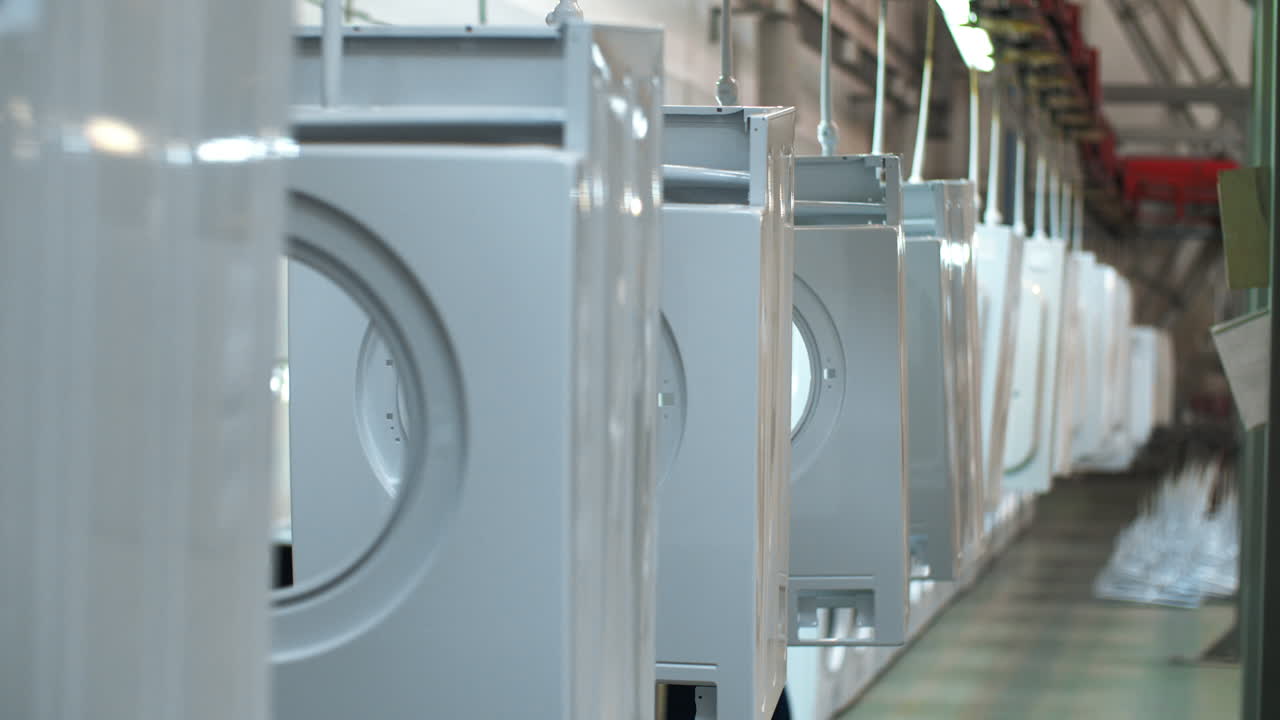 White washing machine moving on conveyor. Production household appliances