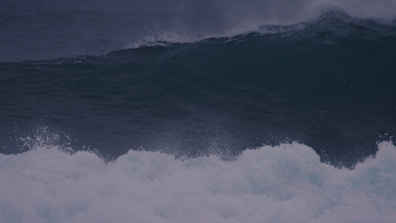 Surfer paddles through icy waves in Arctic waters of Iceland, preparing for an epic ride