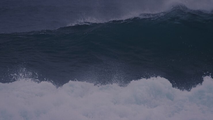 Surfer paddles through icy waves in Arctic waters of Iceland, preparing for an epic ride