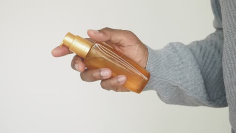 person holding a bottle of hair oil