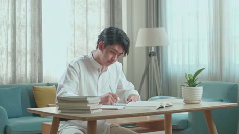 家で勉強する若い男
