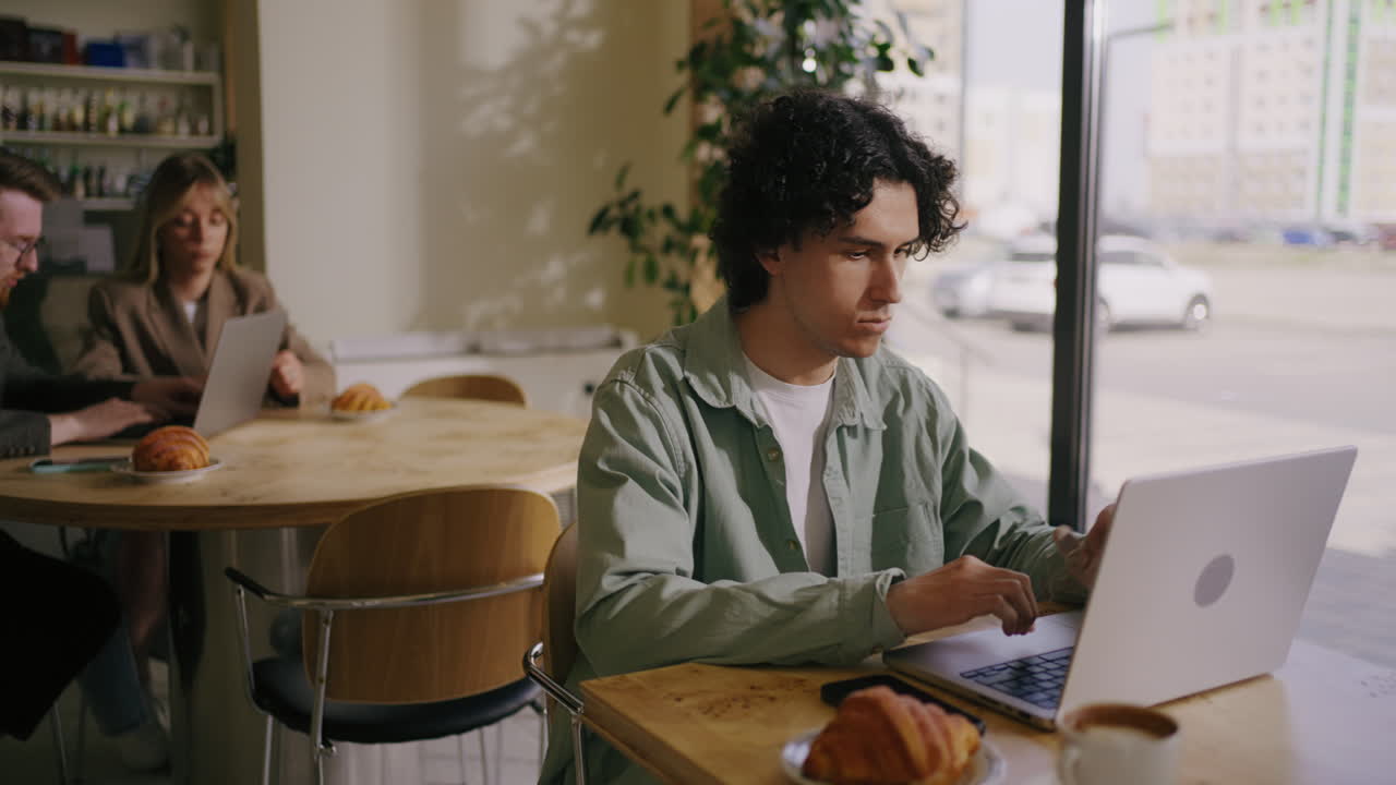 Man working on laptop in cafe