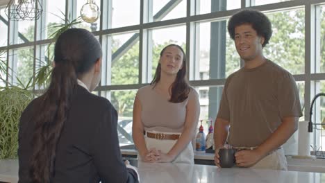 three workers in their 20's talking in an office setting with stable video