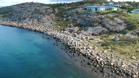 Toma-Aérea-De-Drones-De-Una-Villa-Con-Vistas-A-Una-Costa-Rocosa-Del-Océano-En-La-Costa-Oeste-De-Suecia-En-Halland-En-Las-Afueras-De-Gotemburgo