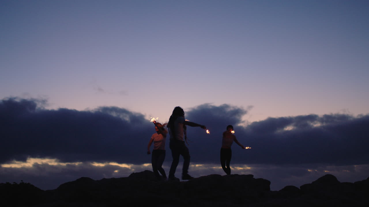 즐거운 행복을 축하하며 행복한 손을 흔들며 폭죽을 춤추는 친구들의 그룹