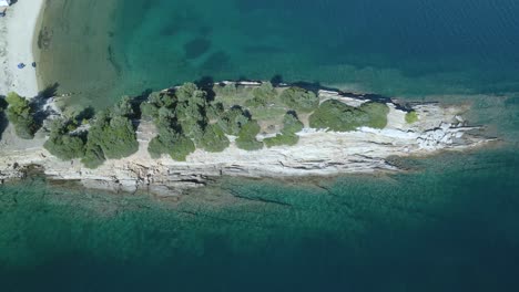 clip de drone de 4k sobre una formación rocosa en las aguas azules tropicales de toroni en chalkidiki