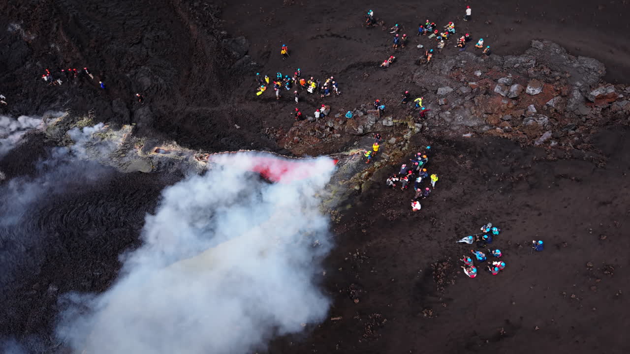 Vista aerea dell'eruzione dell'Etna con persone, che mostra la potenza primordiale della natura