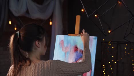 woman painting an abstract piece in an art studio