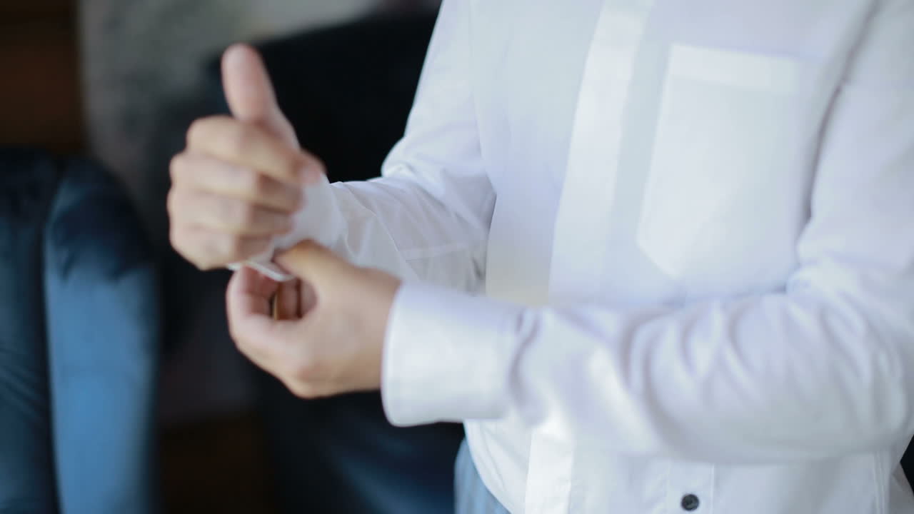 Close-up of a man fixing his cufflink. Businessman dresses shirt.