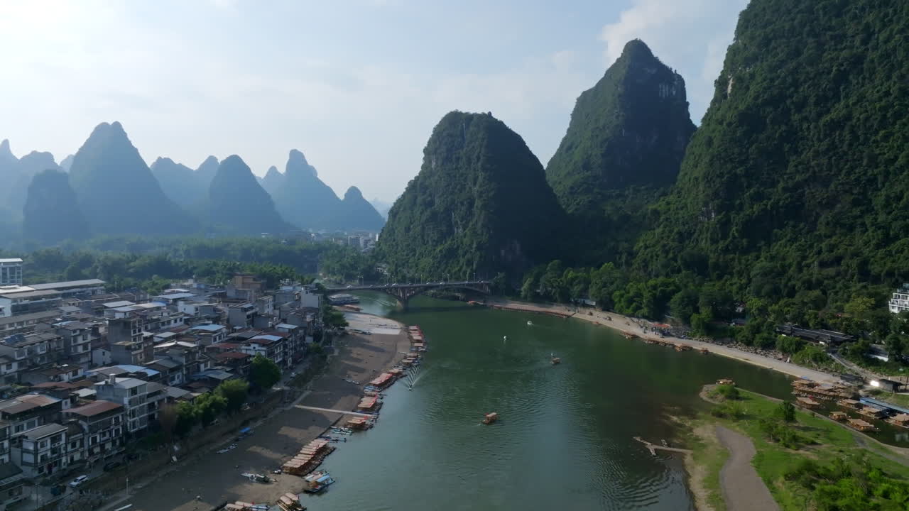 Drone flying toward the Yangshuo bridge, sunny, summer day in Guangxi, China