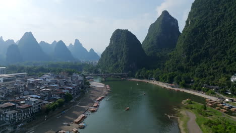 drone flying toward the yangshuo bridge, sunny, summer day in guangxi, china