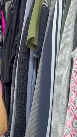 young woman in casual clothes chooses elegant blouse in store