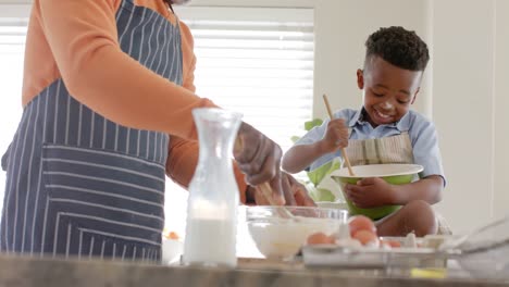 Feliz-Abuelo-Y-Nieto-Afroamericano-Horneando-En-La-Cocina,-Cámara-Lenta