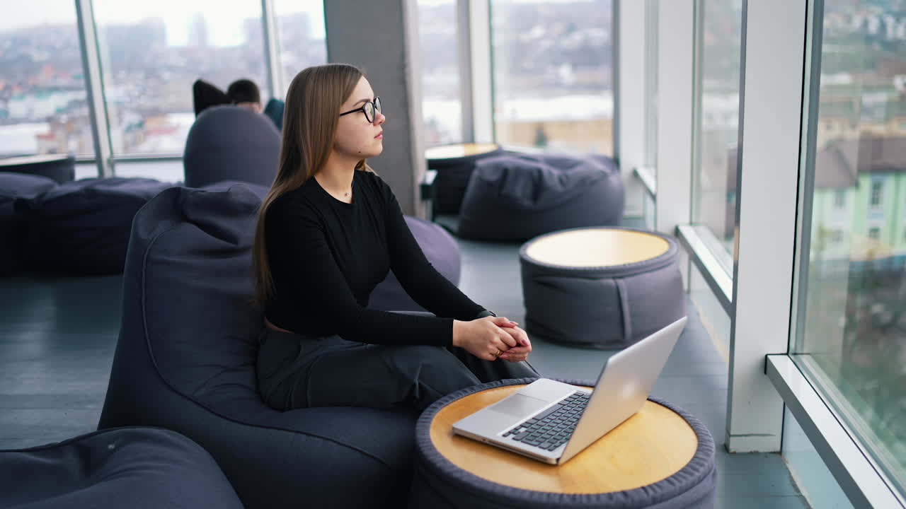 young woman wearing eyeglasses working on laptop computer