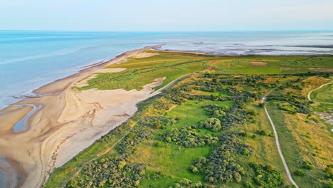 Discover-the-idyllic-charm-of-a-golden-hour-coastal-scene-through-breathtaking-aerial-drone-footage:-estuary,-sandbanks,-ocean,-and-marshlands