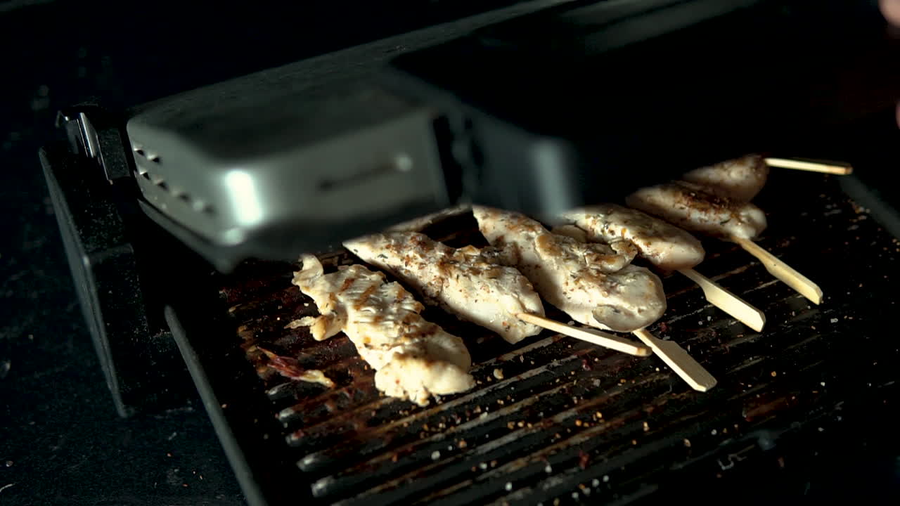 close-up Steaming grilled meat, smoke from chicken meat lying on the grill, slow motion