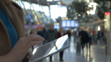 Woman-spending-time-with-tablet-PC-at-the-airport