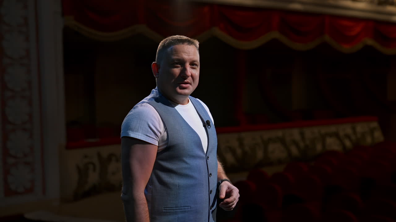 Actor in medical mask on theatre scene. Man rehearsing on stage and taking off protective mask while leading monologue. Pandemic in the world.