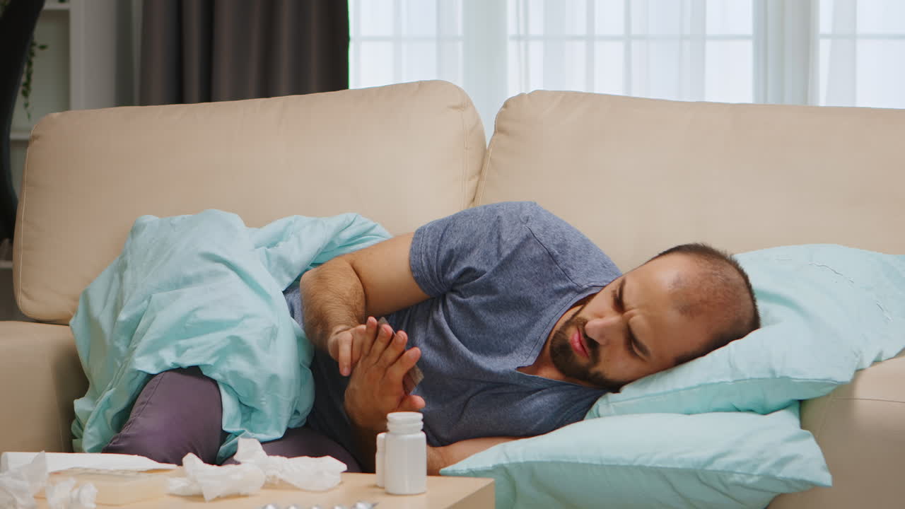 Sick man lying on sofa
