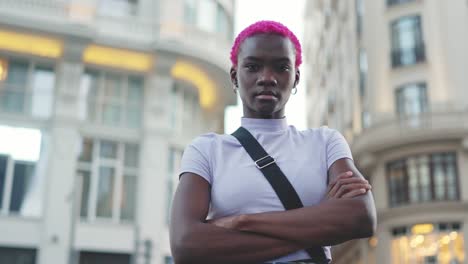 confident young person with pink hair in urban setting