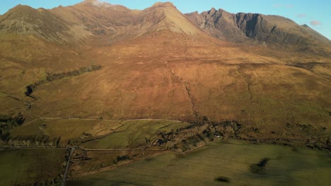 Slow-pan-up-revealing-Red-Cuillin-mountain-peaks-at-sunet-at-Glenbrittle-Isle-of-Skye-Scotland