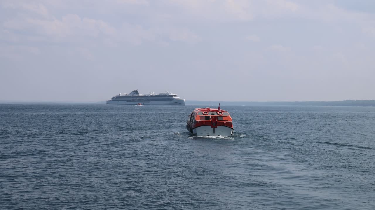 A lifeboat and a cruise ship on the ocean