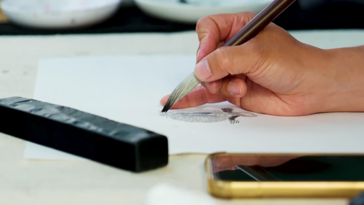 Slow Motion Footage of a Japanese Man Painting a Nihonga, a Traditional Japanese Painting, with Brushes and Black Ink