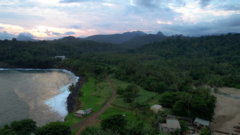 Aerial-view-backwards-over-houses-at-Boca-do-Inferno,-dusk-in-Agua-Izé,-Sao-Tome