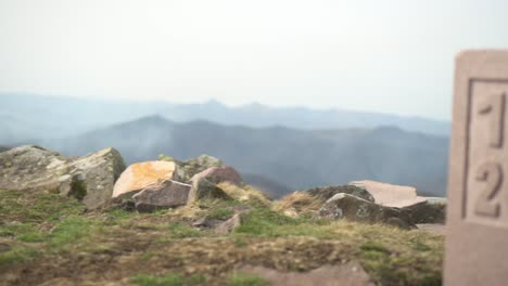 Panoramic-view-from-the-top-of-a-mountain-in-Euskal-Herria,-with-a-large-rock-bearing-the-inscription-1512-2022