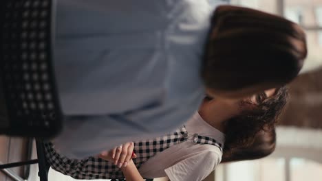 vertical video: a brunette girl with curly hair wearing glasses communicates with a girl with a bob during group therapy