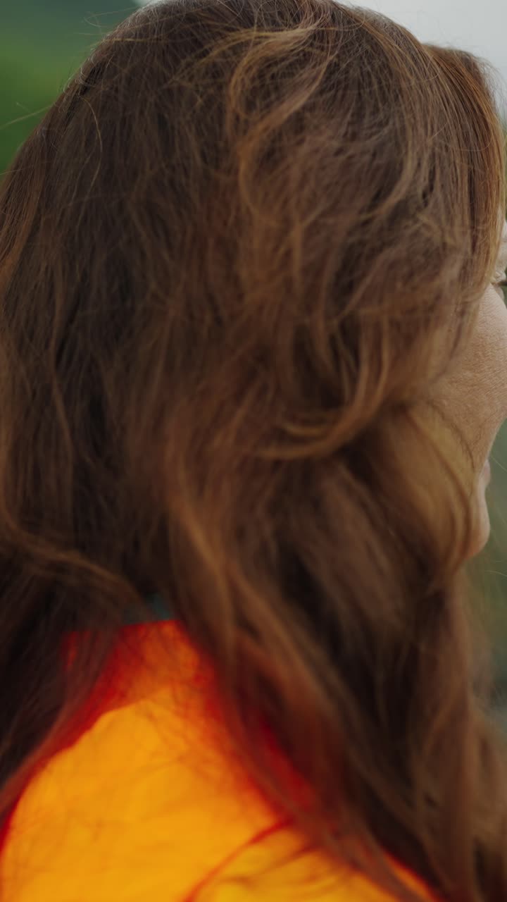 Donna felice che sorride e si guarda intorno all'aperto