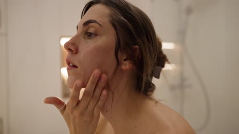 mujer lavándose la cara en el baño